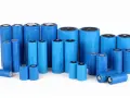 Un gruppo di batterie cilindriche blu, alcune NiMH, altre al litio, di varie dimensioni, disposte su sfondo bianco.