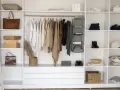 Armadio fai da te ben organizzato con abiti appesi, borse, scatole e accessori.