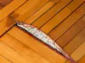 Parquet gonfio e danneggiato, forse per un incidente con il ferro da stiro. Il legno si è sollevato e la sottostruttura è visibile.