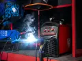 Saldatore in azione, scintille luminose e fumo. La saldatrice Stamos S-MULTI 195 IGBT è pronta per l'uso. Guida per come scegliere una saldatrice.