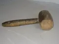 Un vecchio mazzuolo di legno, strumento che evoca il suo significato di forza e lavoro manuale.