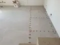 Posa di piastrelle con livellatori. La miscela cemento e collante attende il suo momento.
