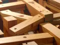 Legno grezzo, tagliato e forato, pronto per diventare mobili. Travi di pino grezzo, perfette per costruire.