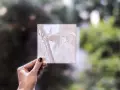 Litofania stampa 3d di Gandalf, tenuta in mano contro uno sfondo sfocato di alberi.