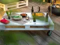Tavolo con pallet fai da te, pronto per un barbecue con birre, patatine e pomodorini.