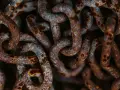 Dettaglio di una catena di ferro arrugginita, con macchie di ossido marrone e grigio. Utile per capire come togliere la ruggine da una catena di ferro.