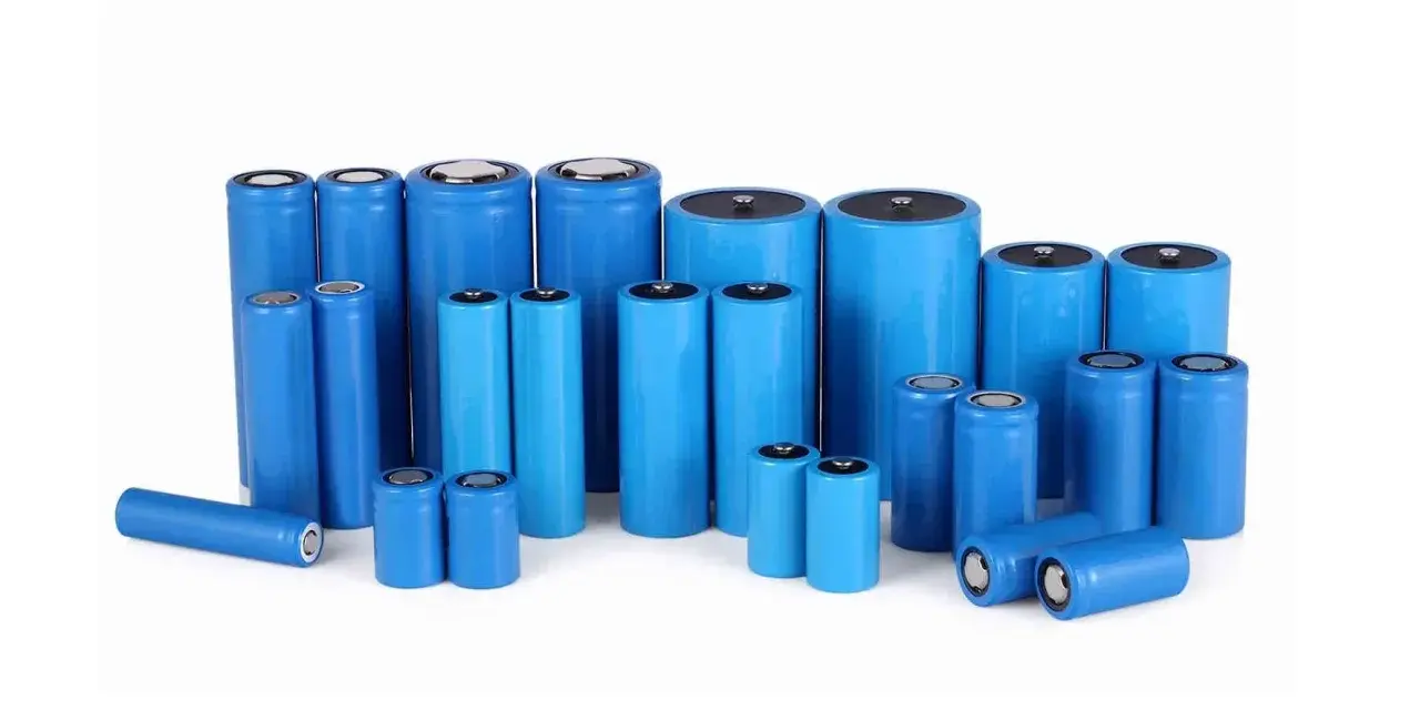 Un gruppo di batterie cilindriche blu, alcune NiMH, altre al litio, di varie dimensioni, disposte su sfondo bianco.