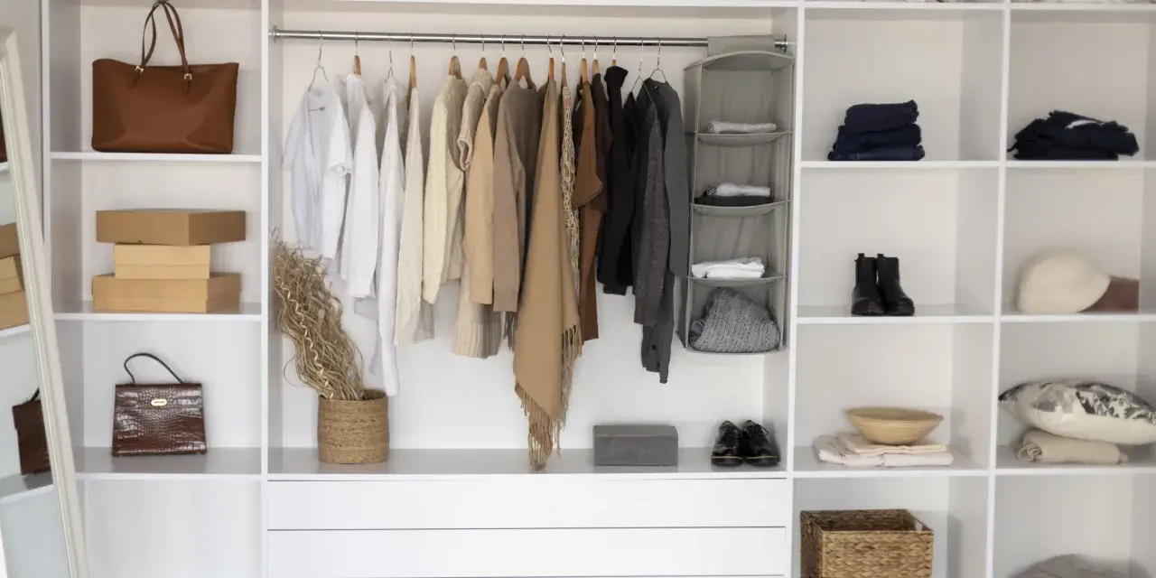 Armadio fai da te ben organizzato con abiti appesi, borse, scatole e accessori.