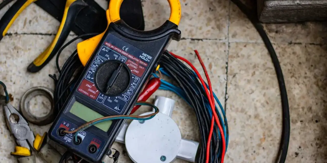 Strumenti elettrici, tra cui pinze e multimetro, pronti per imparare come spellare i cavi elettrici velocemente.