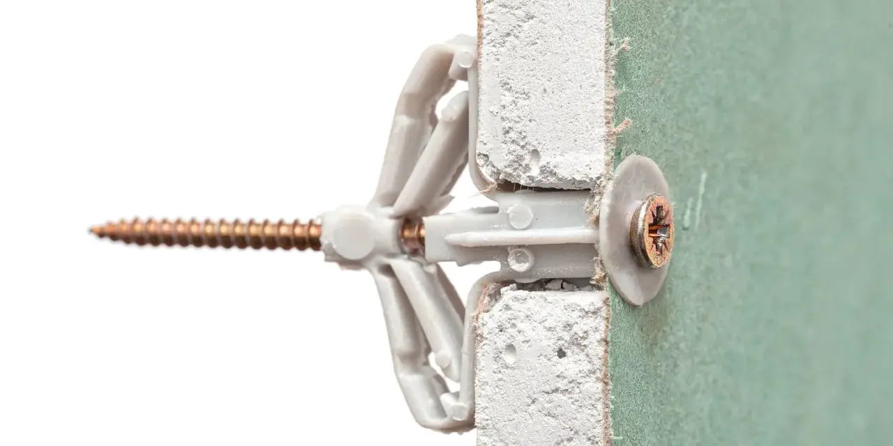 Un tassello Fisher e una vite inseriti in un muro di cartongesso. Illustra come mettere fisher nel muro per un fissaggio sicuro.