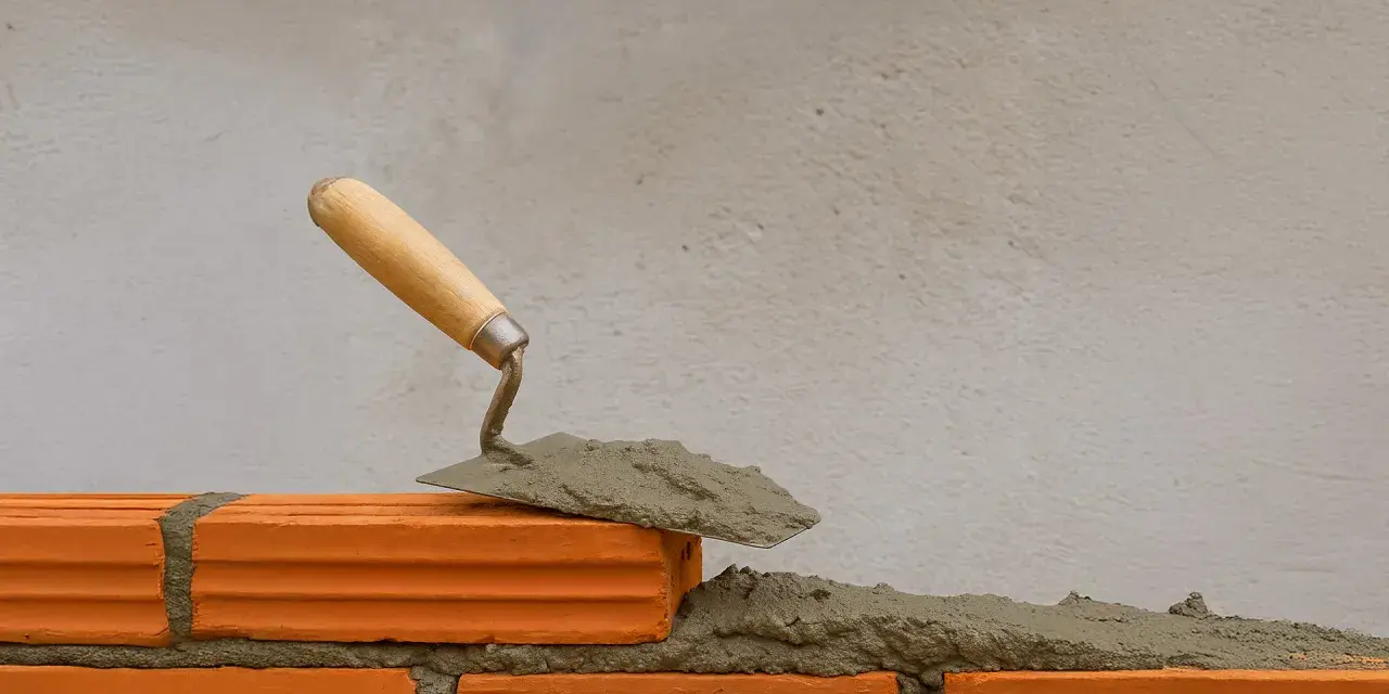 Una cazzuola con la malta pronta per costruire un muro. La malta a cosa serve? A tenere insieme i mattoni, creando strutture solide.