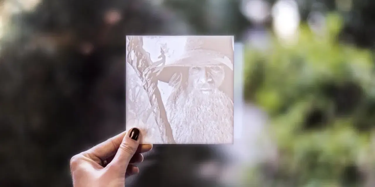 Litofania stampa 3d di Gandalf, tenuta in mano contro uno sfondo sfocato di alberi.