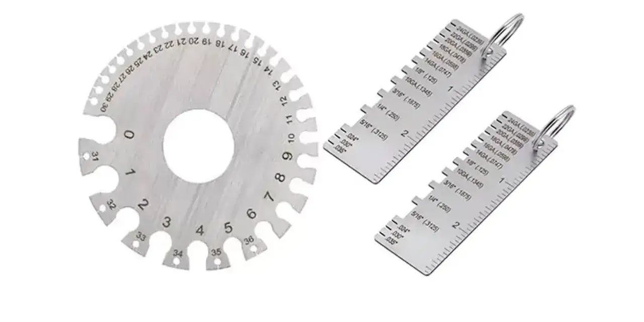 Strumenti di misurazione metallici, tra cui un disco graduato e due righelli, utili per determinare la portata di un calibro.