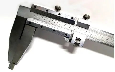 Un calibro di precisione con scala in millimetri e frazioni di millimetro, ideale per misurazioni di alta accuratezza, come un calibro cinquantesimale.