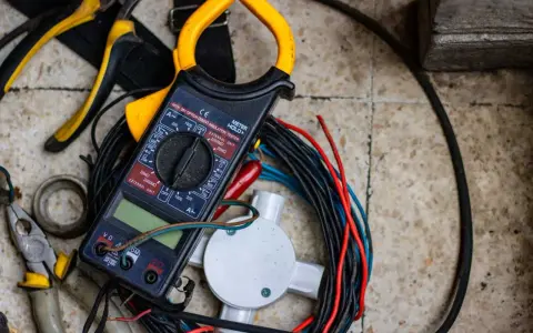 Strumenti elettrici, tra cui pinze e multimetro, pronti per imparare come spellare i cavi elettrici velocemente.