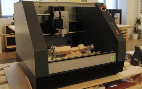 Macchina CNC in azione, che mostra come fresare il legno con trapano, creando trucioli di legno.
