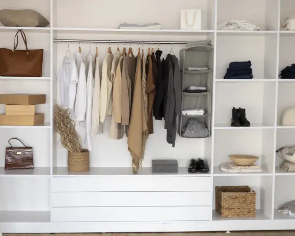 Armadio fai da te ben organizzato con abiti appesi, borse, scatole e accessori.