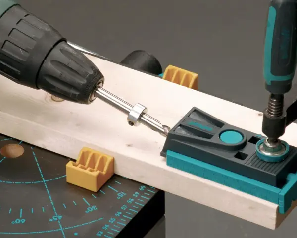 Attrezzo per guidare il trapano su un pezzo di legno, con morsetto e guida per fori precisi.