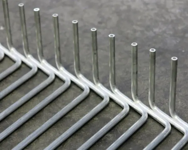 Tubi in acciaio inox piegati a formare un rastrello. La tecnica per come piegare un tubo in acciaio inox è fondamentale per ottenere queste forme precise.