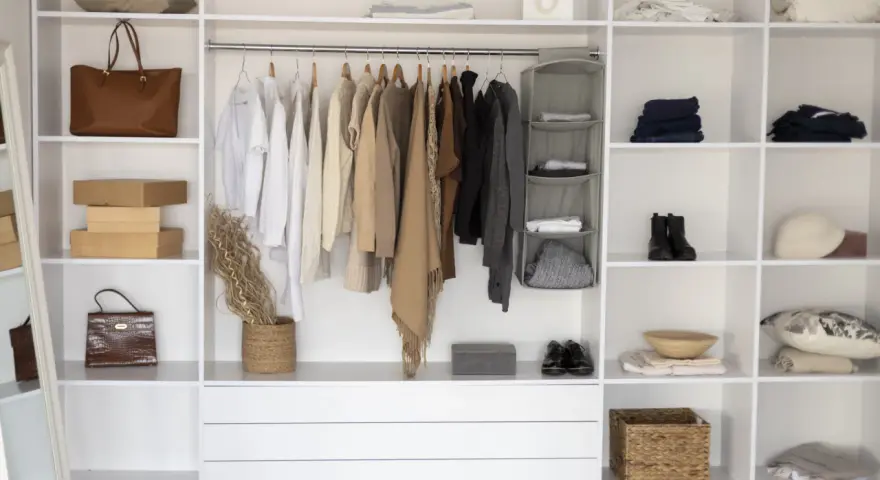 Armadio fai da te ben organizzato con abiti appesi, borse, scatole e accessori.