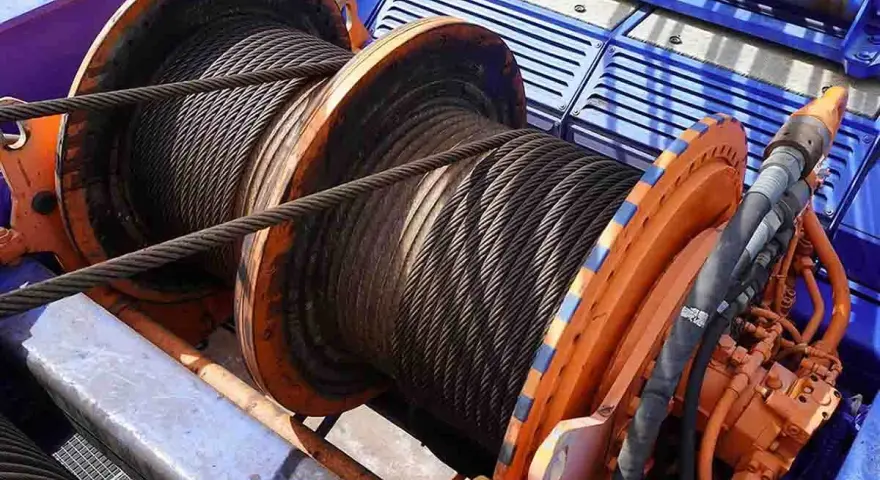 Bobine di argano e verricello, con cavi d'acciaio avvolti. La differenza tra argano e verricello è spesso legata alla loro potenza e applicazione.