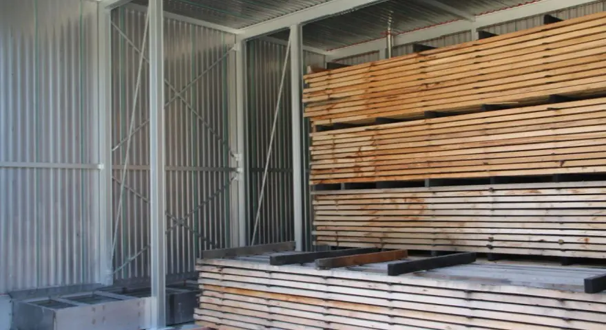 Legno impilato in un capannone, pronto per stagionare. Un progetto fai-da-te per conservare il legno.