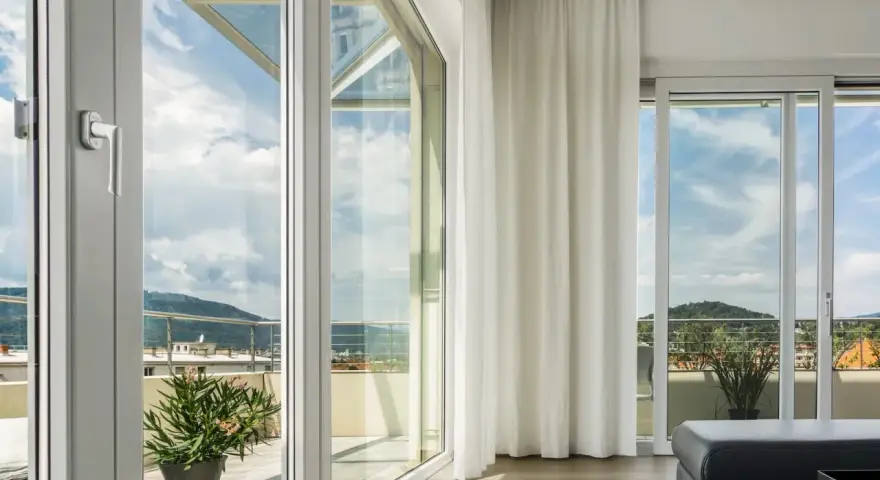 Ampie vetrate con vetro temperato significato di sicurezza e luminosità, con vista su un paesaggio collinare.