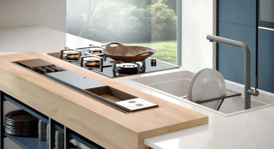 Un elegante montaggio top cucina con piano cottura a gas, lavello e un'isola in legno con vani contenitori.