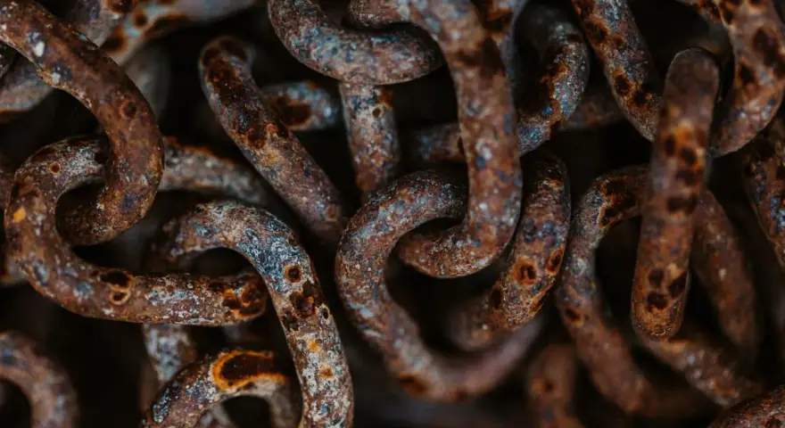 Dettaglio di una catena di ferro arrugginita, con macchie di ossido marrone e grigio. Utile per capire come togliere la ruggine da una catena di ferro.