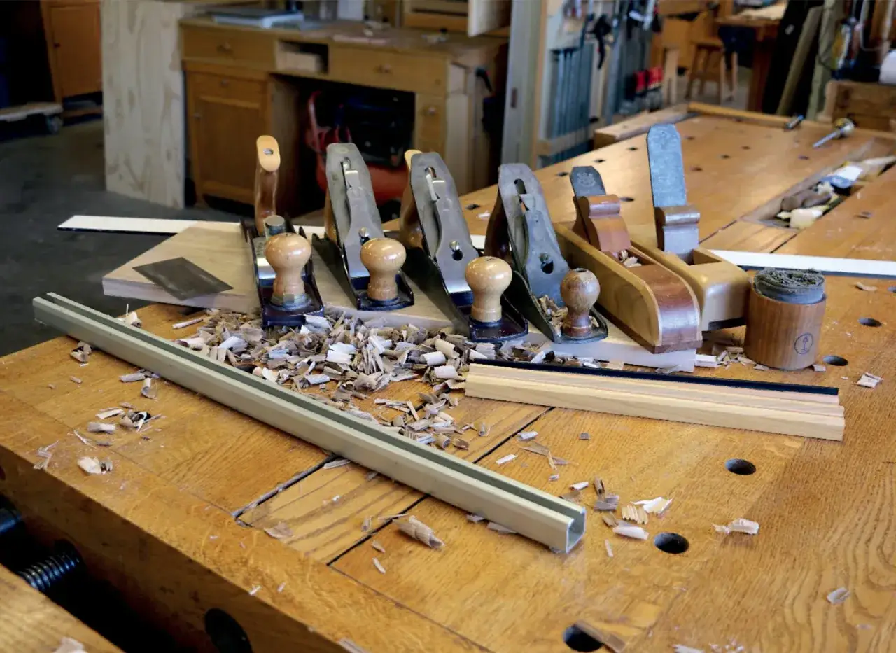 Pialle da falegname su un banco da lavoro, con trucioli di legno. Il piallare significato &egrave; dare forma al legno.