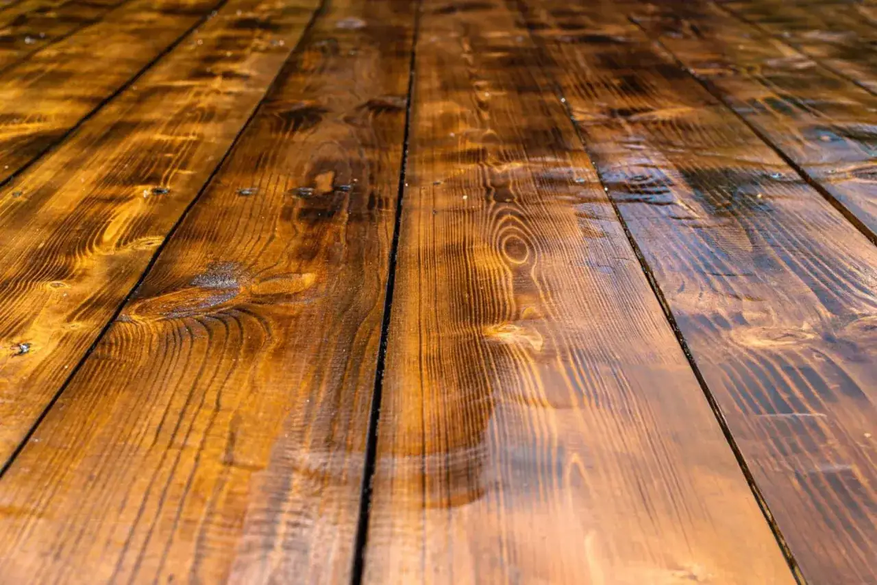 Tavolato di legno scuro e lucido, con venature evidenti. Un effetto che ricorda come invecchiare il legno per un aspetto rustico e vissuto.