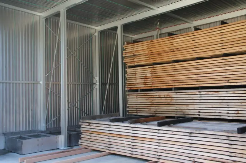 Legno impilato in un capannone, pronto per stagionare. Un progetto fai-da-te per conservare il legno.